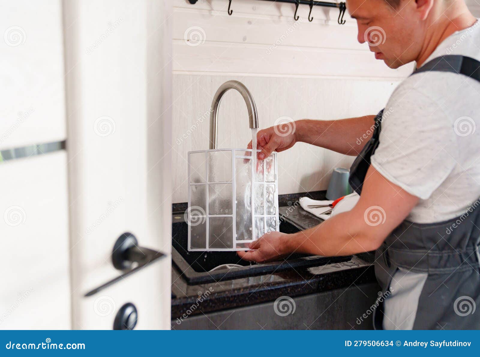 a man flushes the air cleaner filter from the air conditioner.