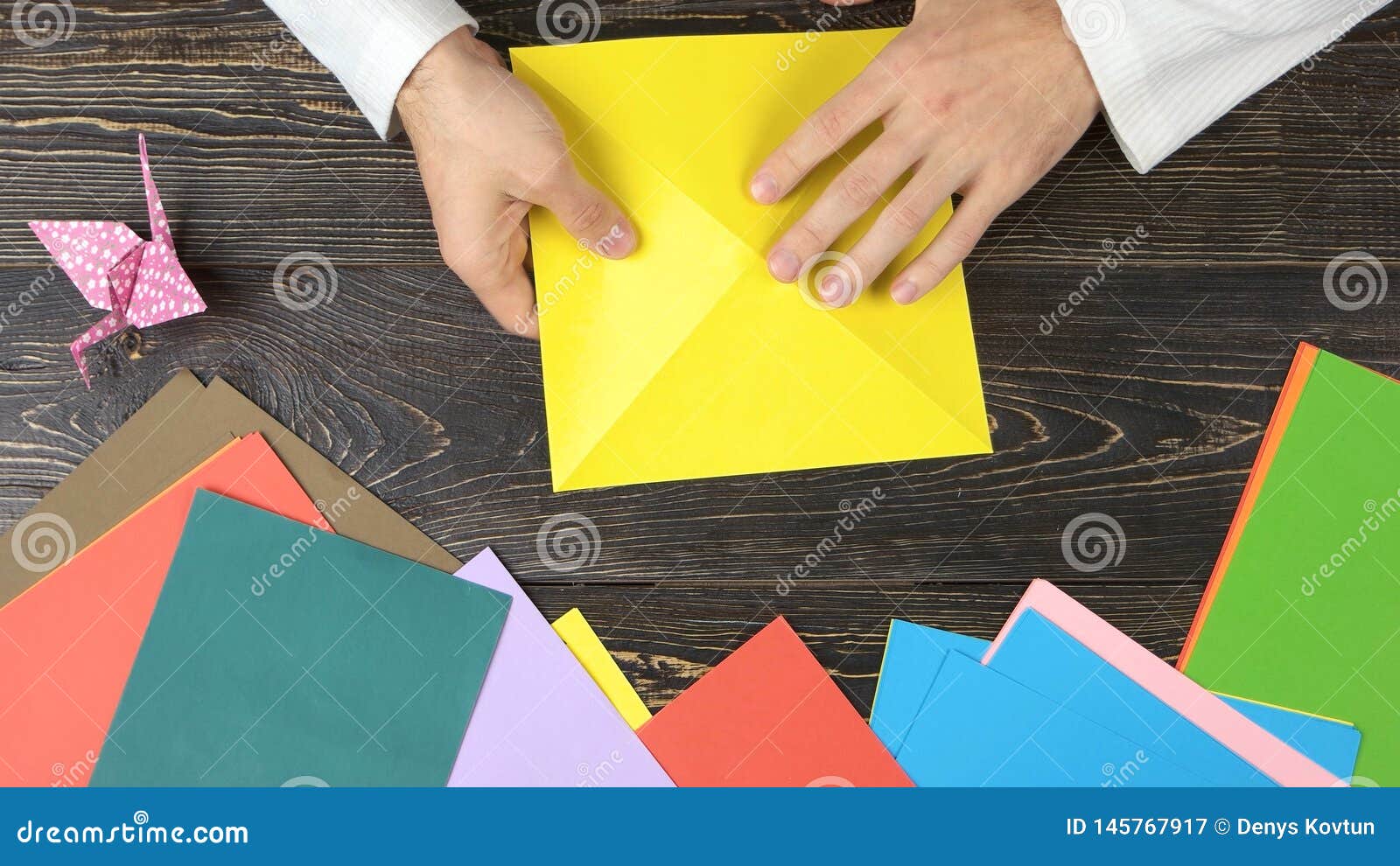 man folding paper as triangle.