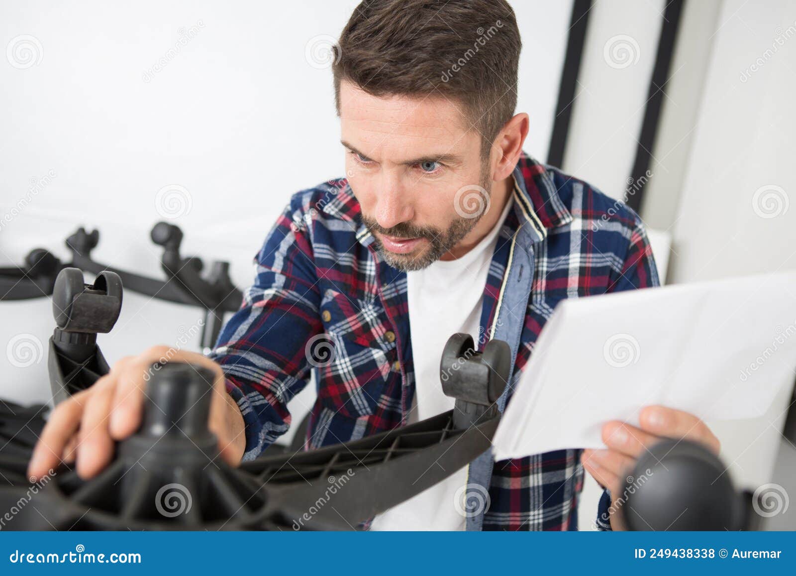 Man Following Instructions To Assemble Office Chair Stock Photo Image