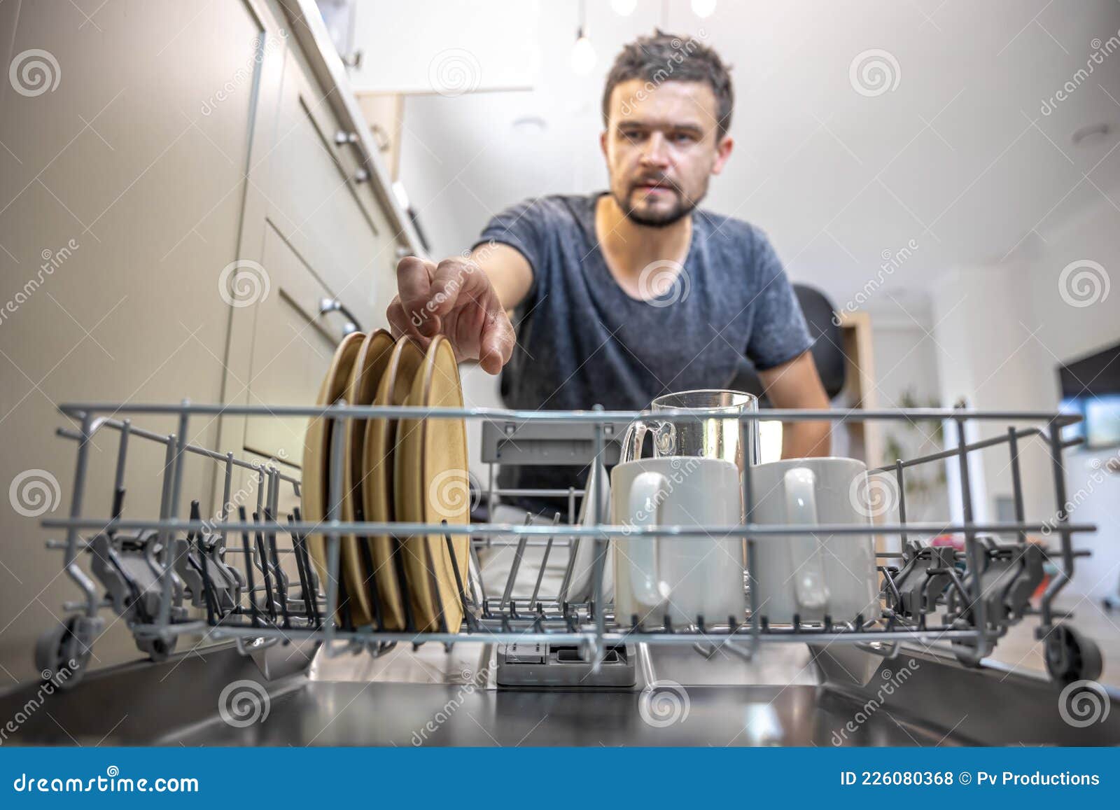 The Man Takes Clean Plates from the Dishwasher Stock Photo Image of