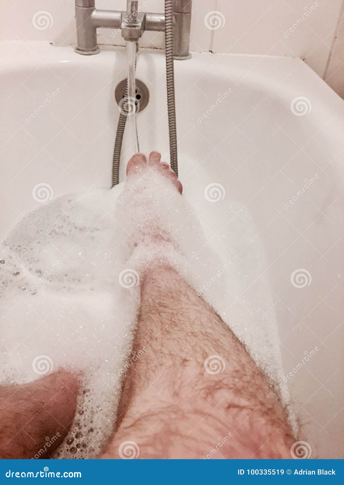 Мужские ноги в ванной с пеной
