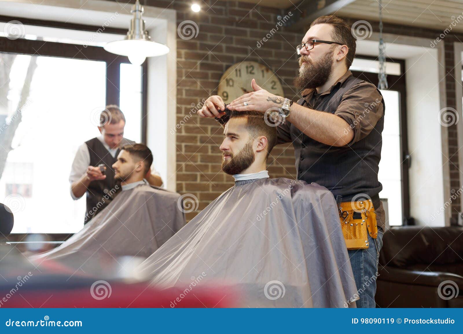 Man Getting Haircut By Hairstylist At Barbershop Stock Image