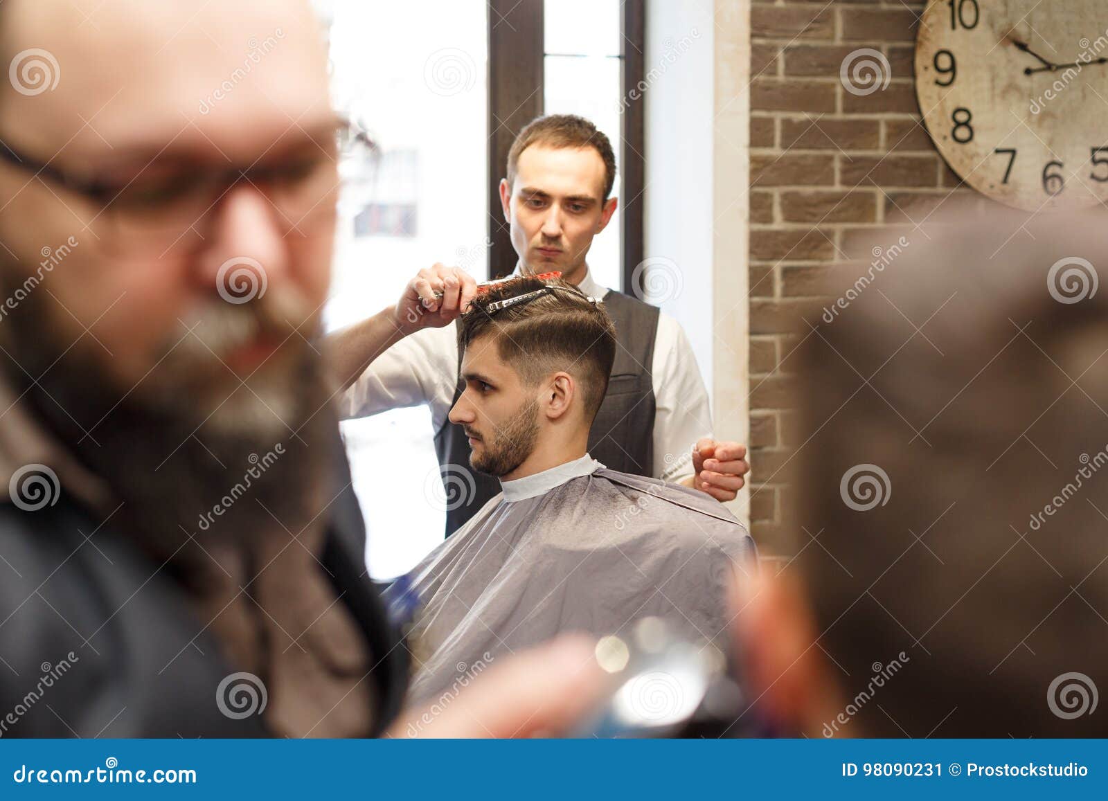 Man Getting Haircut By Hairstylist At Barbershop Stock Image