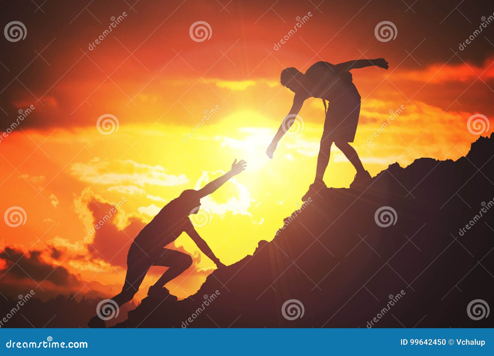 man is giving helping hand. silhouettes of people climbing on mountain at sunset