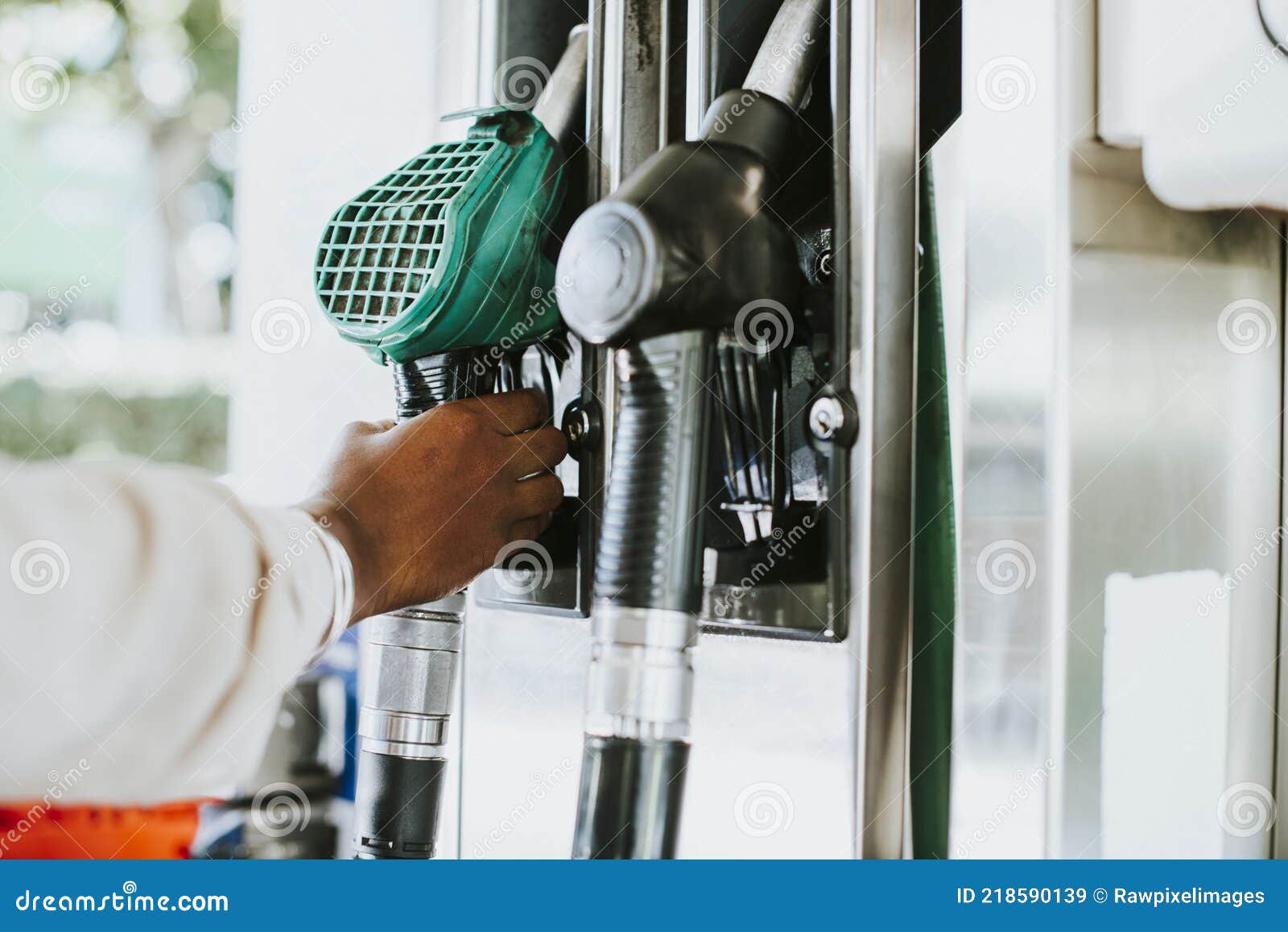 man grabbing a fuel nozzle to refuel his vehicle