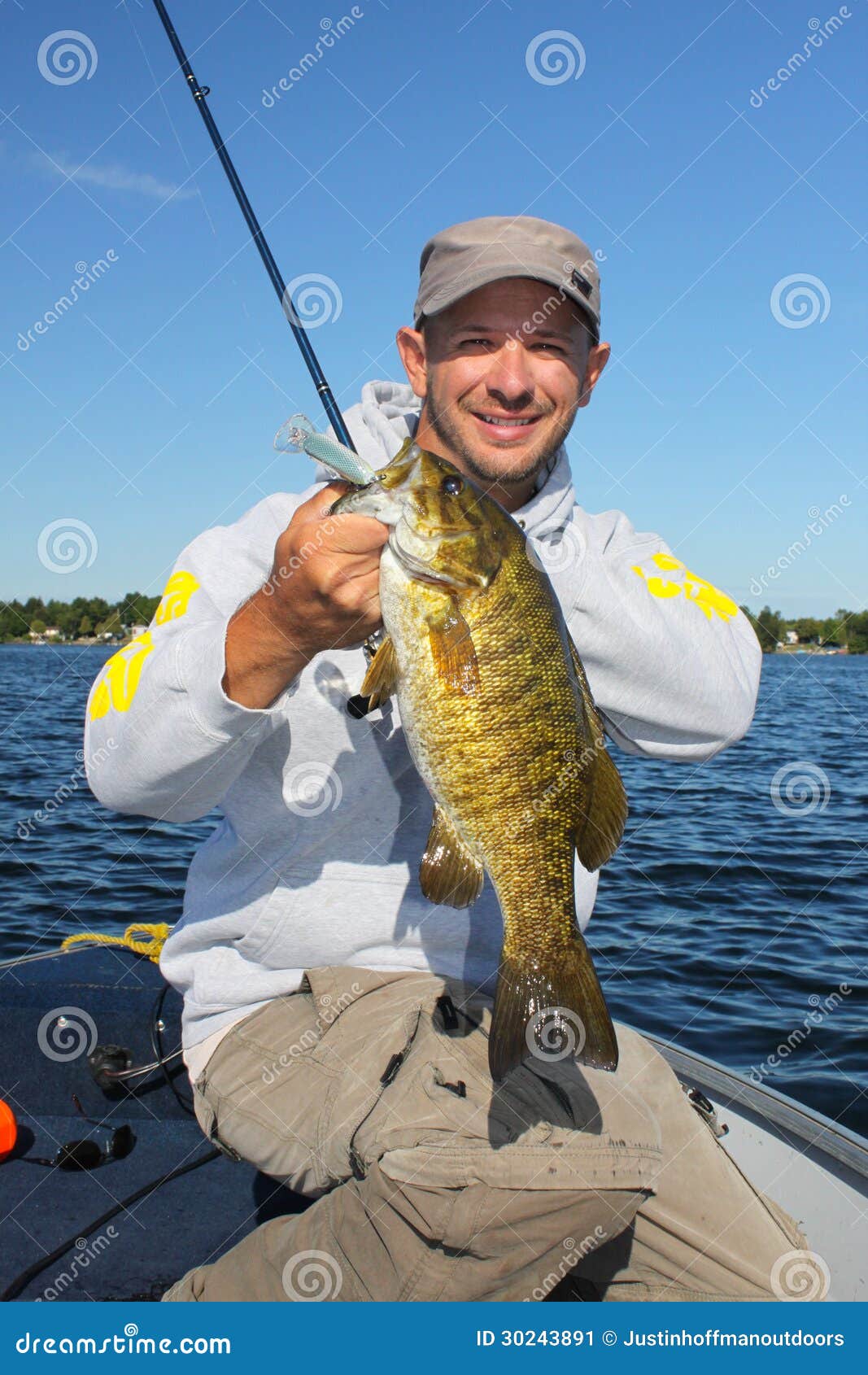 man fishing holding smallmouth bass