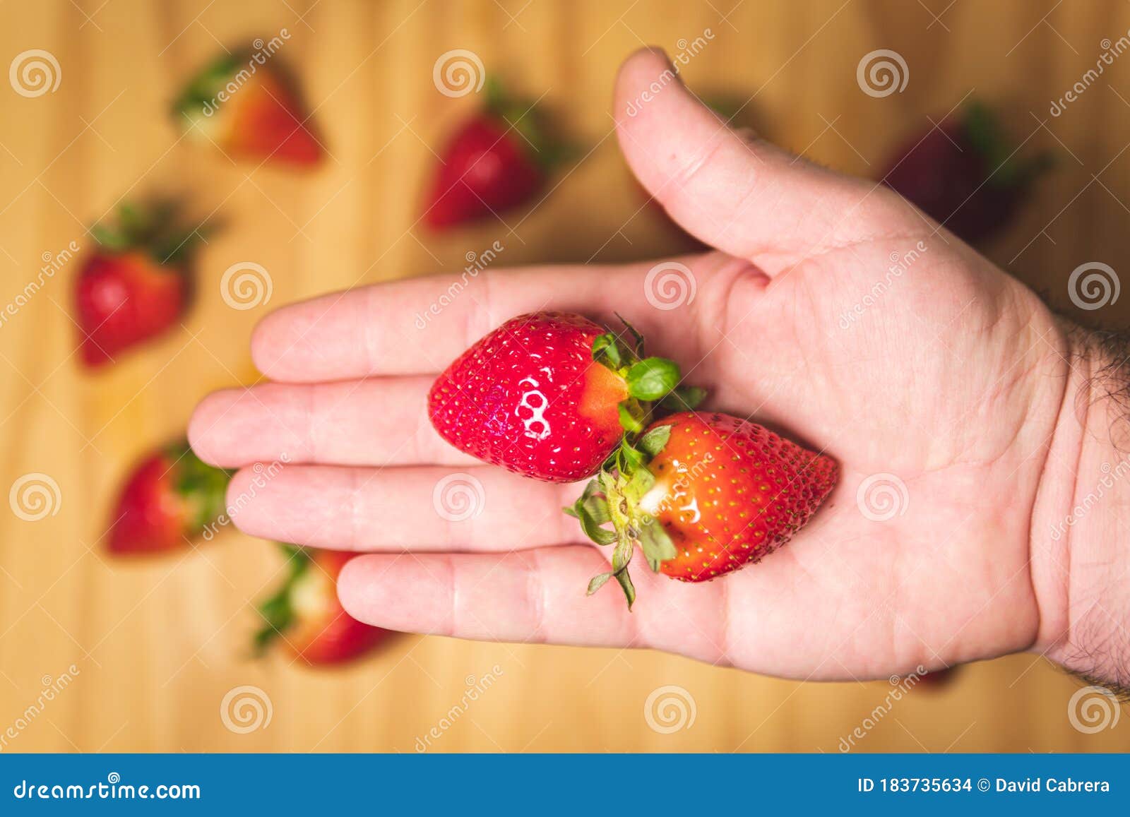 man hand holding fresh juicy strawberries