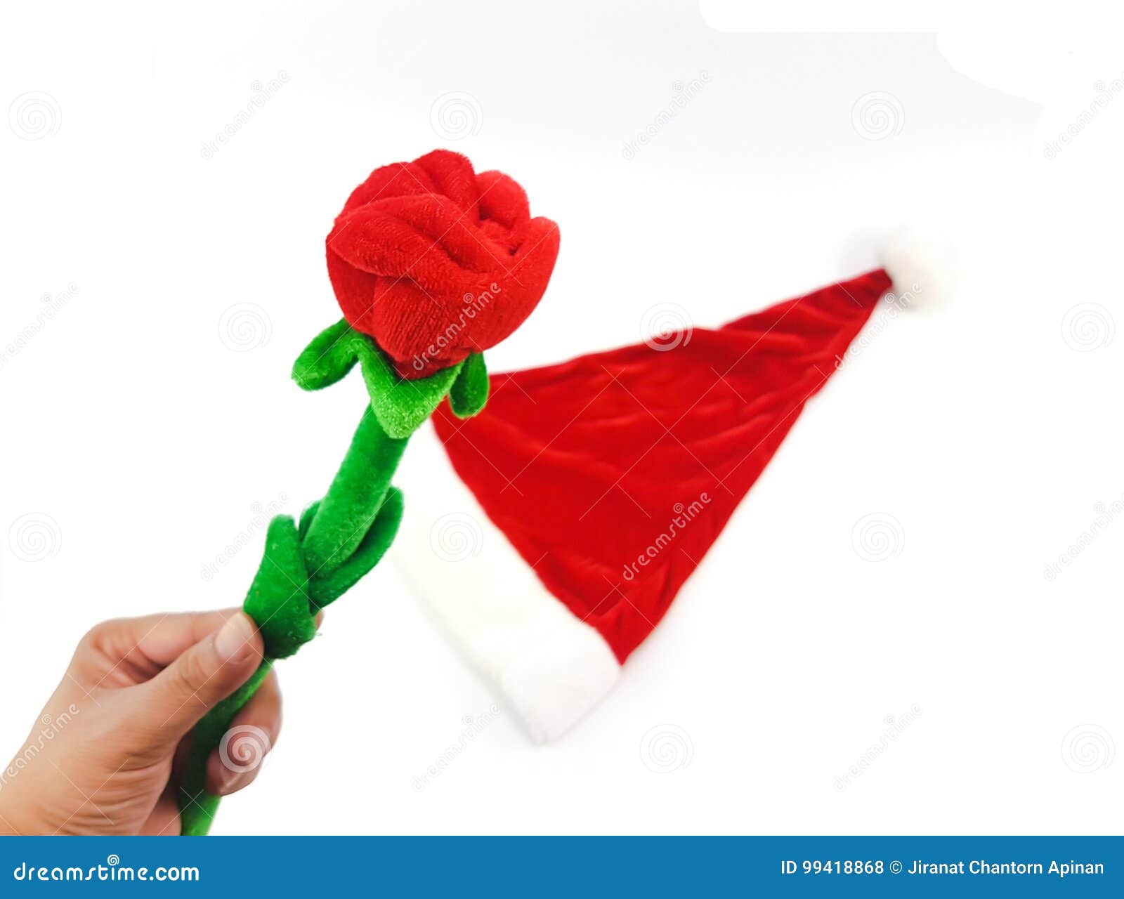 man hand holding the phony red rose with green stalk above santa
