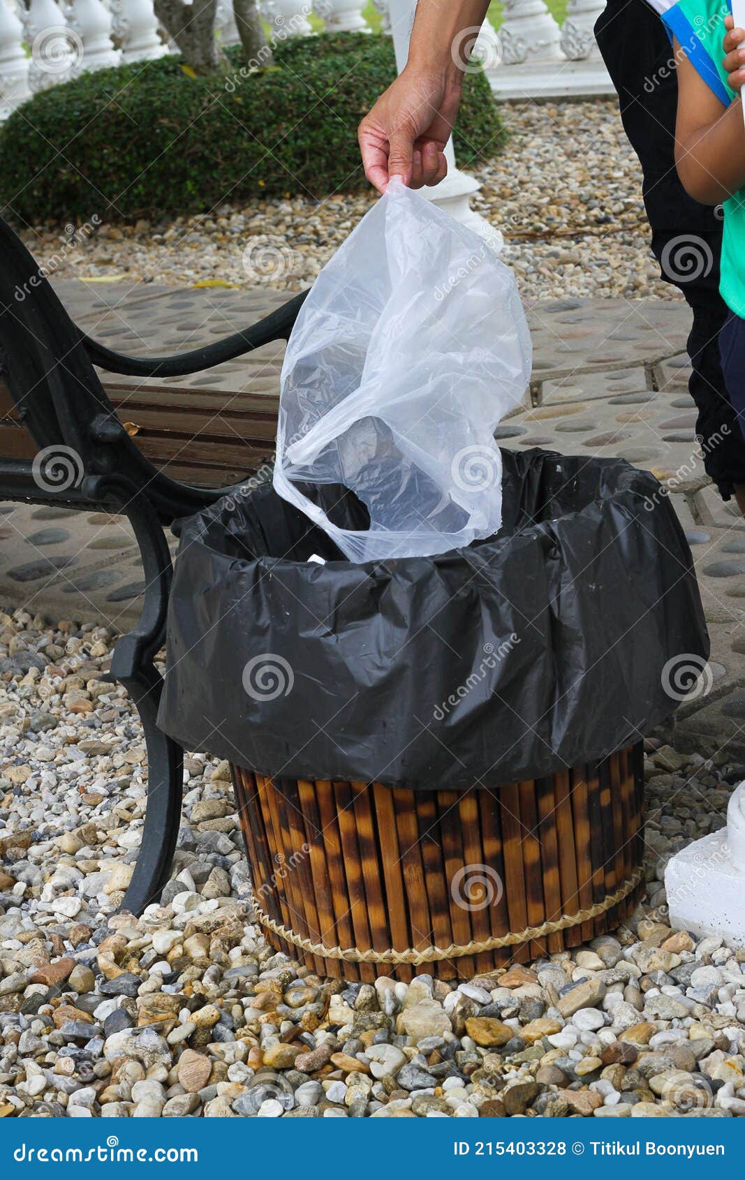 A Man Hand Holding a Plastic Bag into a Garbage Bin Stock Photo Image