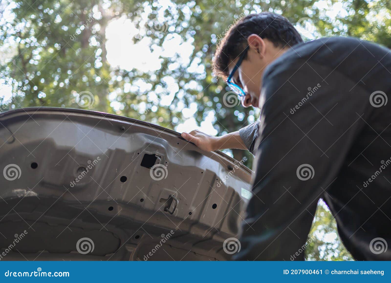 Man` Hand Open Hood of a Broken Car on the Road in the Forest. Car