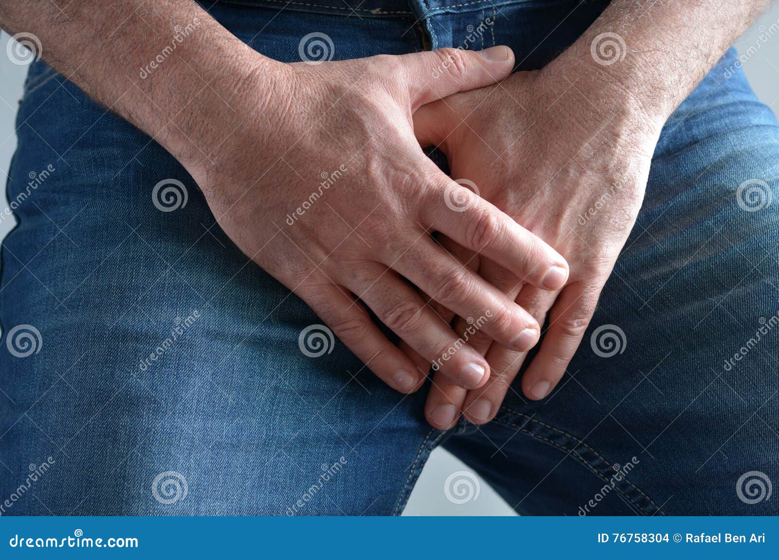 man hands covering his painful crotch