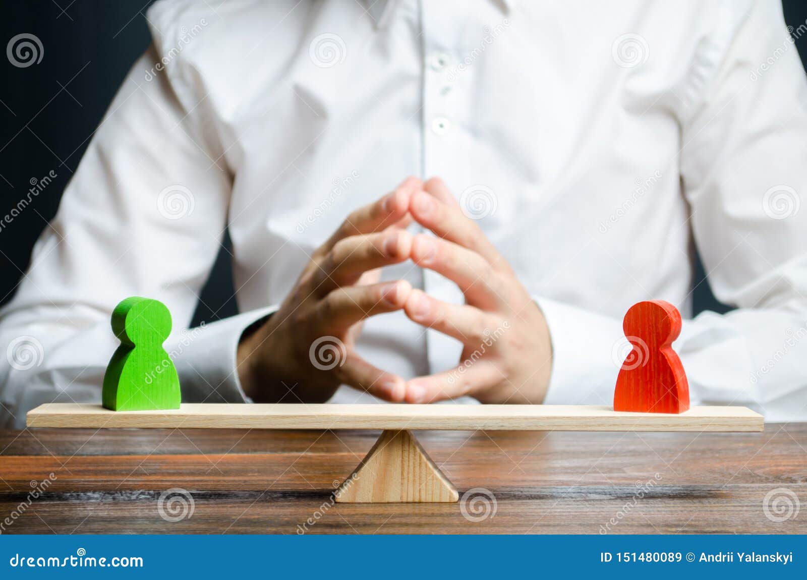 a man with hands in the lock and looks at the rival red and green figures on a scales. the concept of conflict resolution