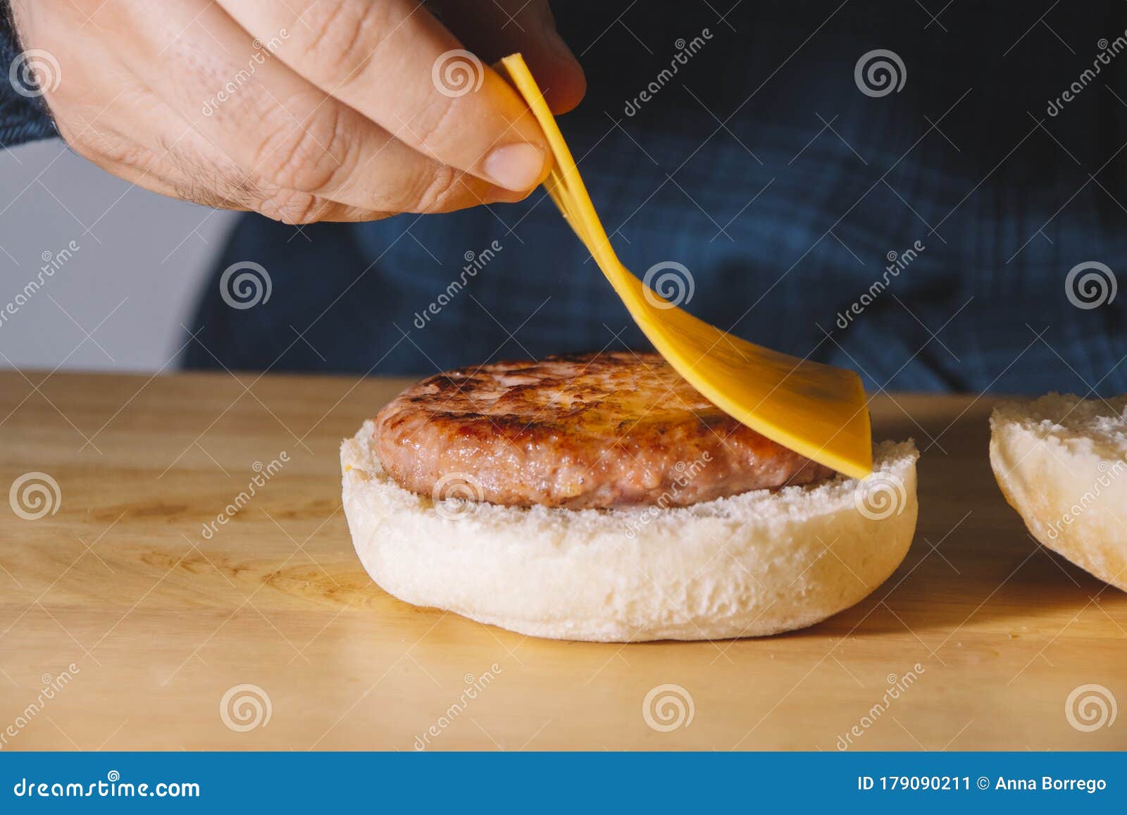 Man Hands Putting on Top of a Burger a Slice of Cheese on a Wooden Board. Cooking Concept Stock Image of cheese, home: 179090211