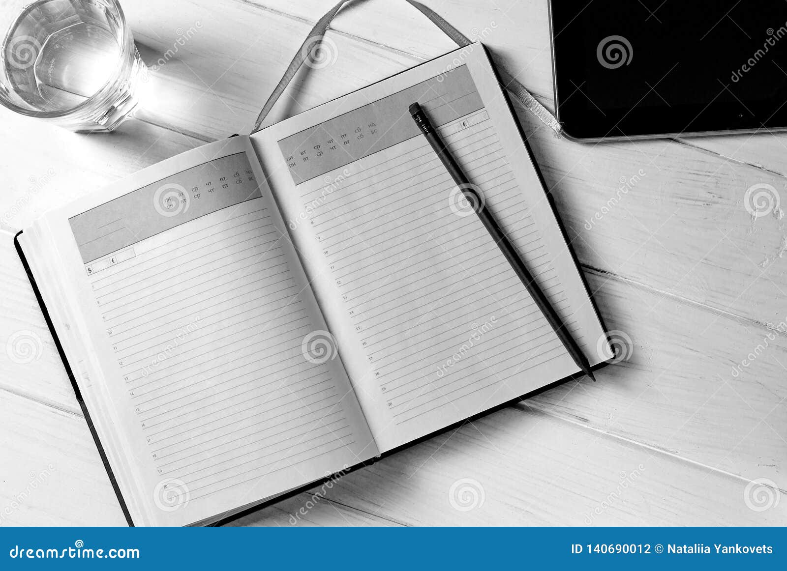 man hands writing notes to the notebook on wooden table in home office