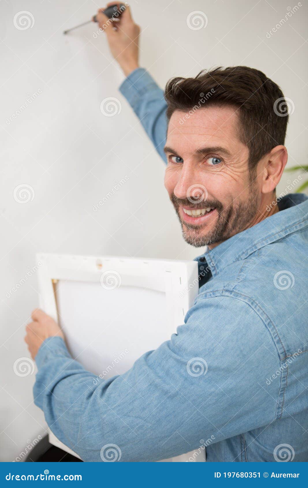 Man Hanging Up Painting on Wall Stock Image Image of home, mouth 197680351