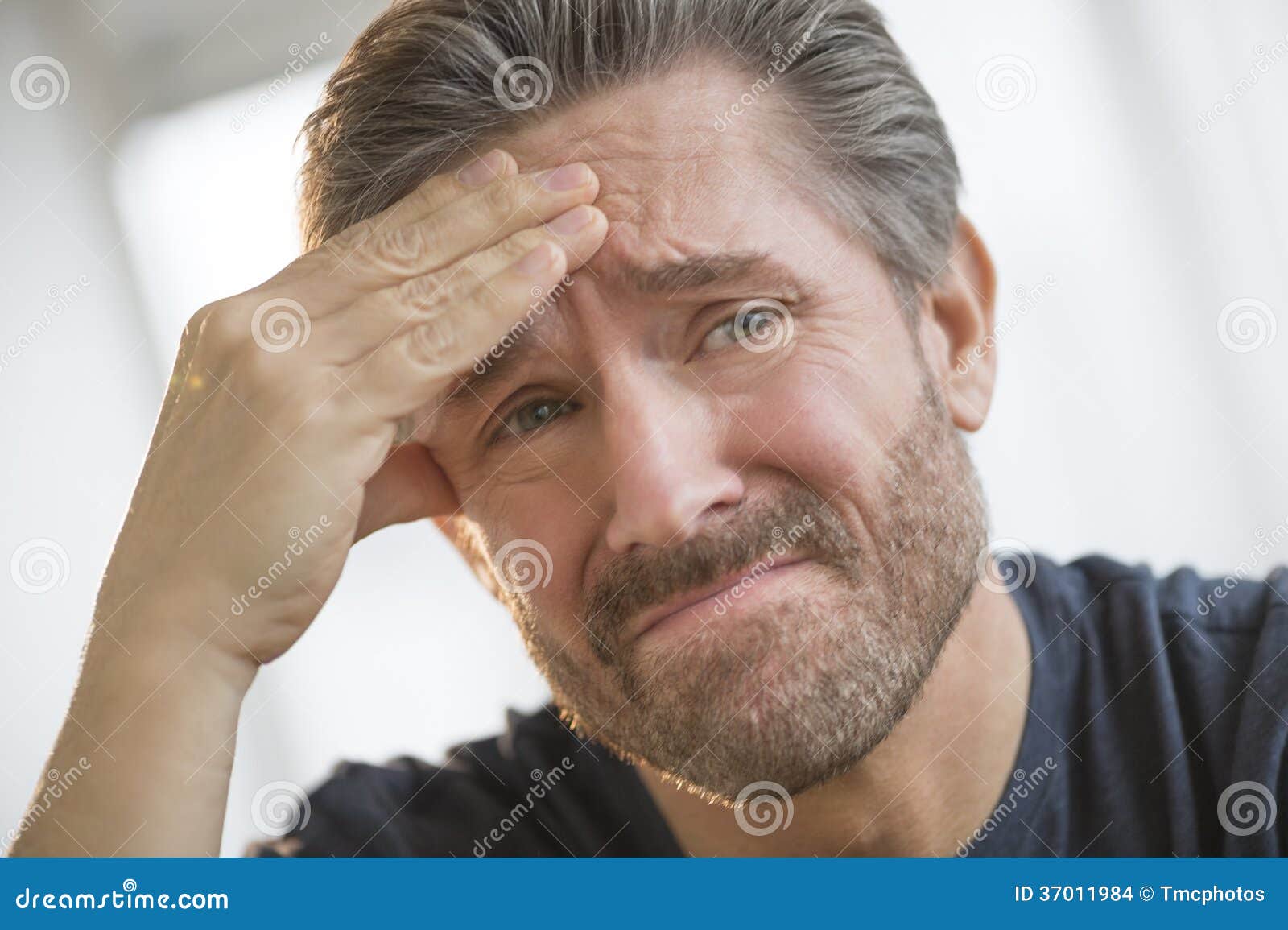 man with headache rubbing forehead