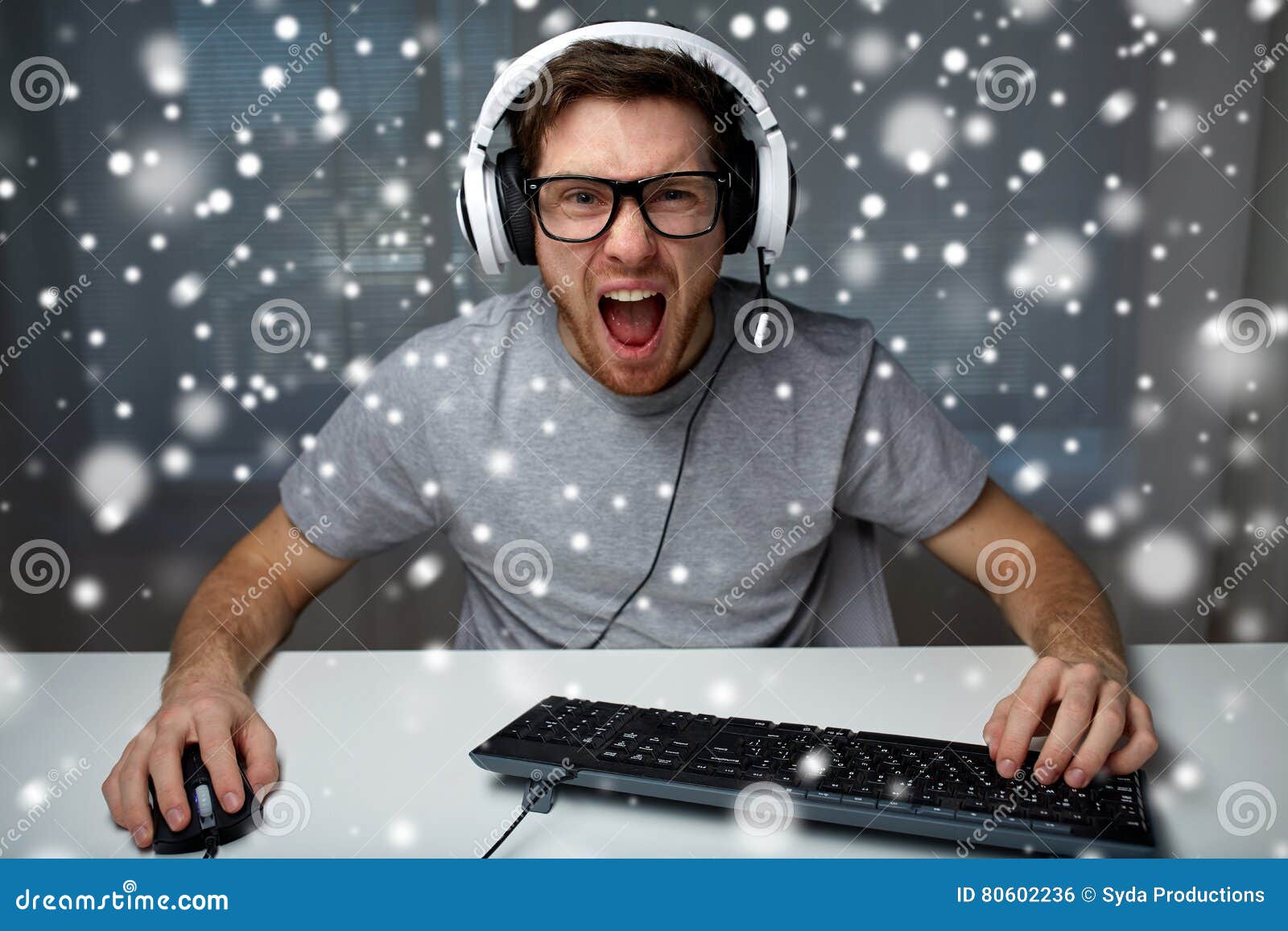 man in headset playing computer video game at home