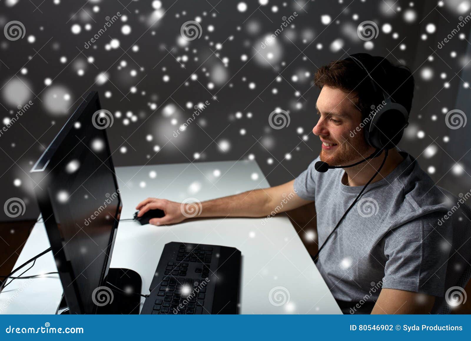 man in headset playing computer video game at home