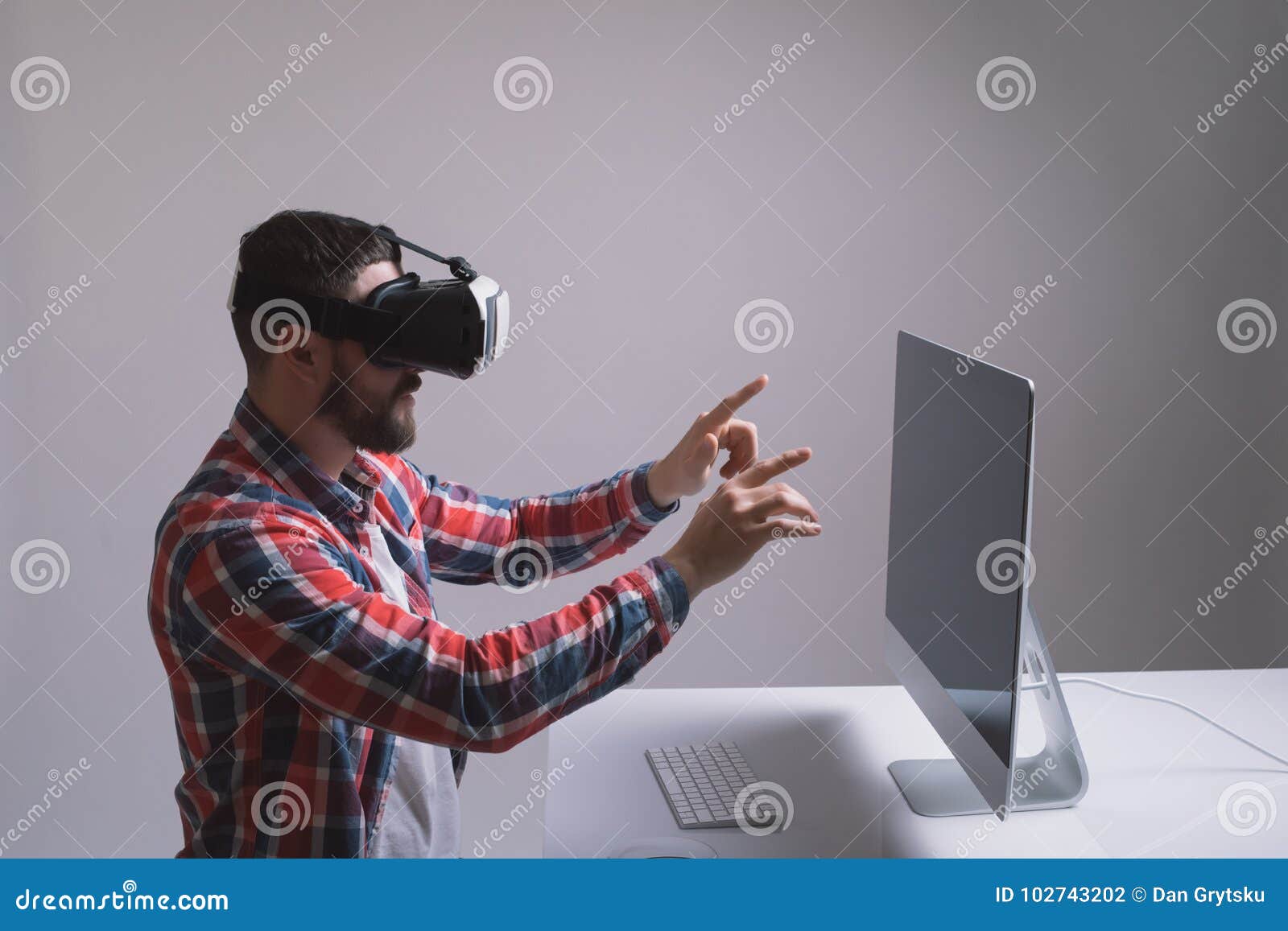 man in helmet virtual reality plays game at desk. man uses vr-headset display with headphones for virtual reality game in office i