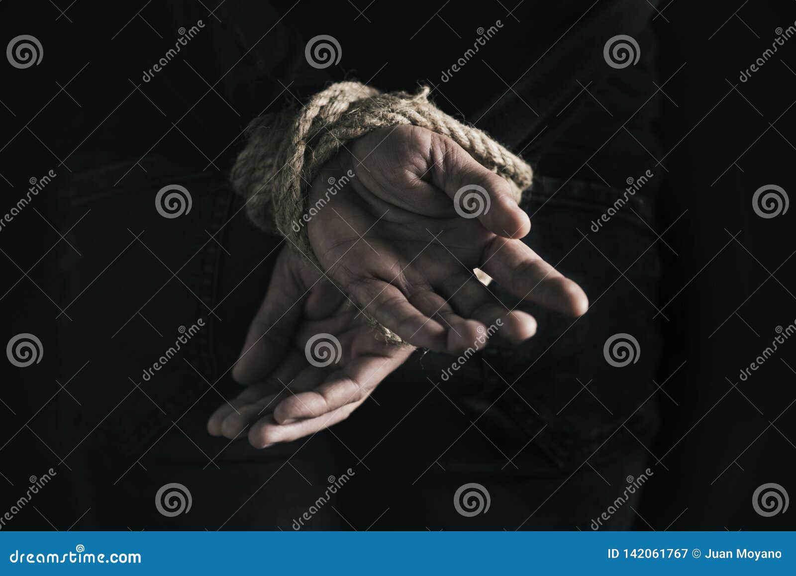 man with his hands tied behind his back