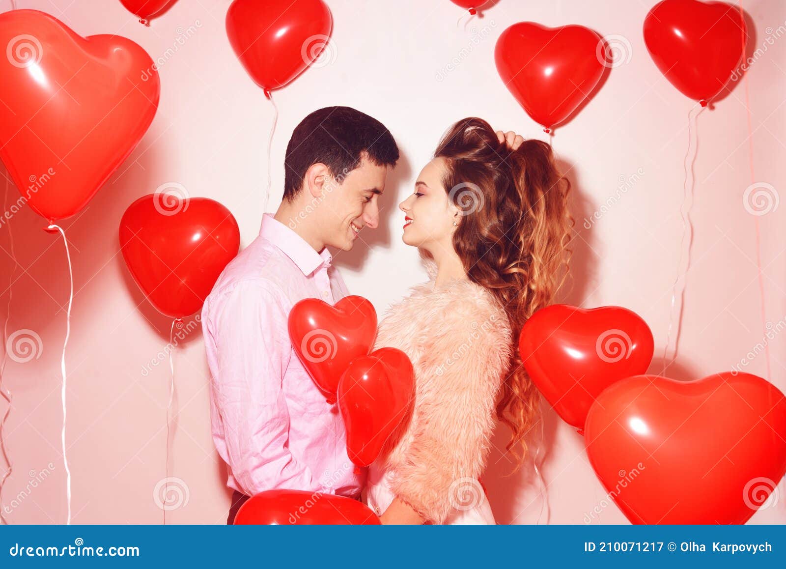 man with his lovely sweetheart girl kiss at lover`s valentine day. valentine couple. couple kiss and hug. on background red