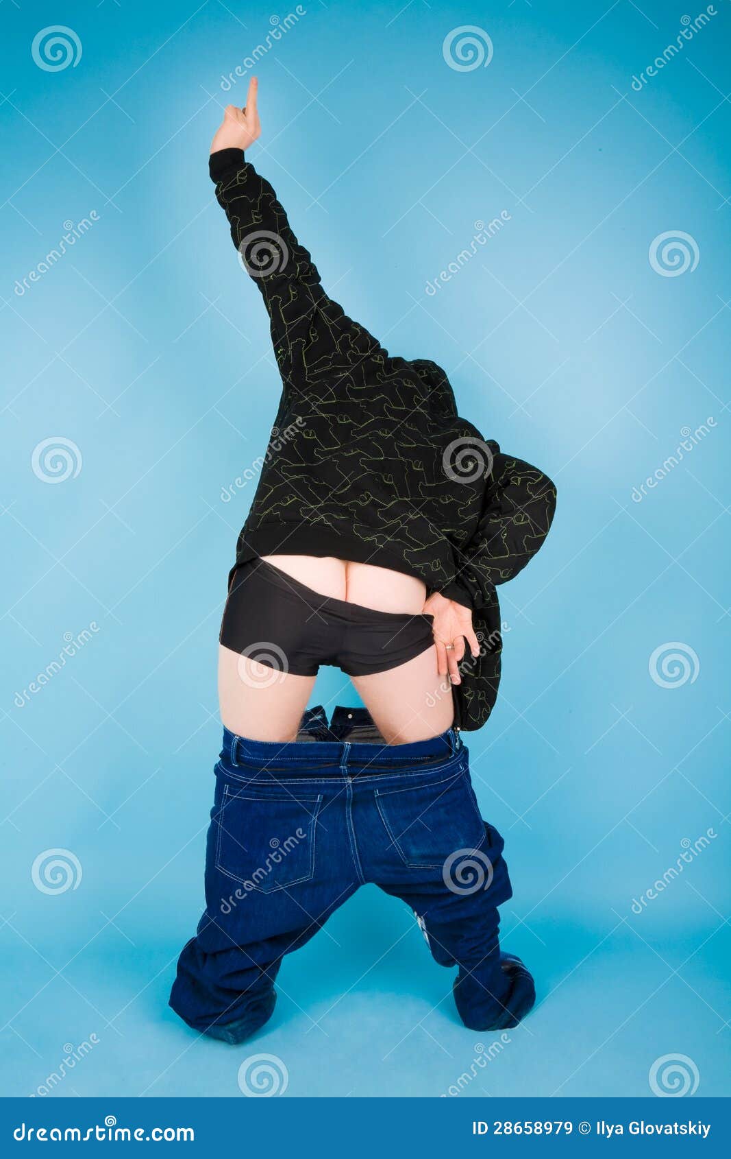 Man with his pants down gesturing on the blue background.