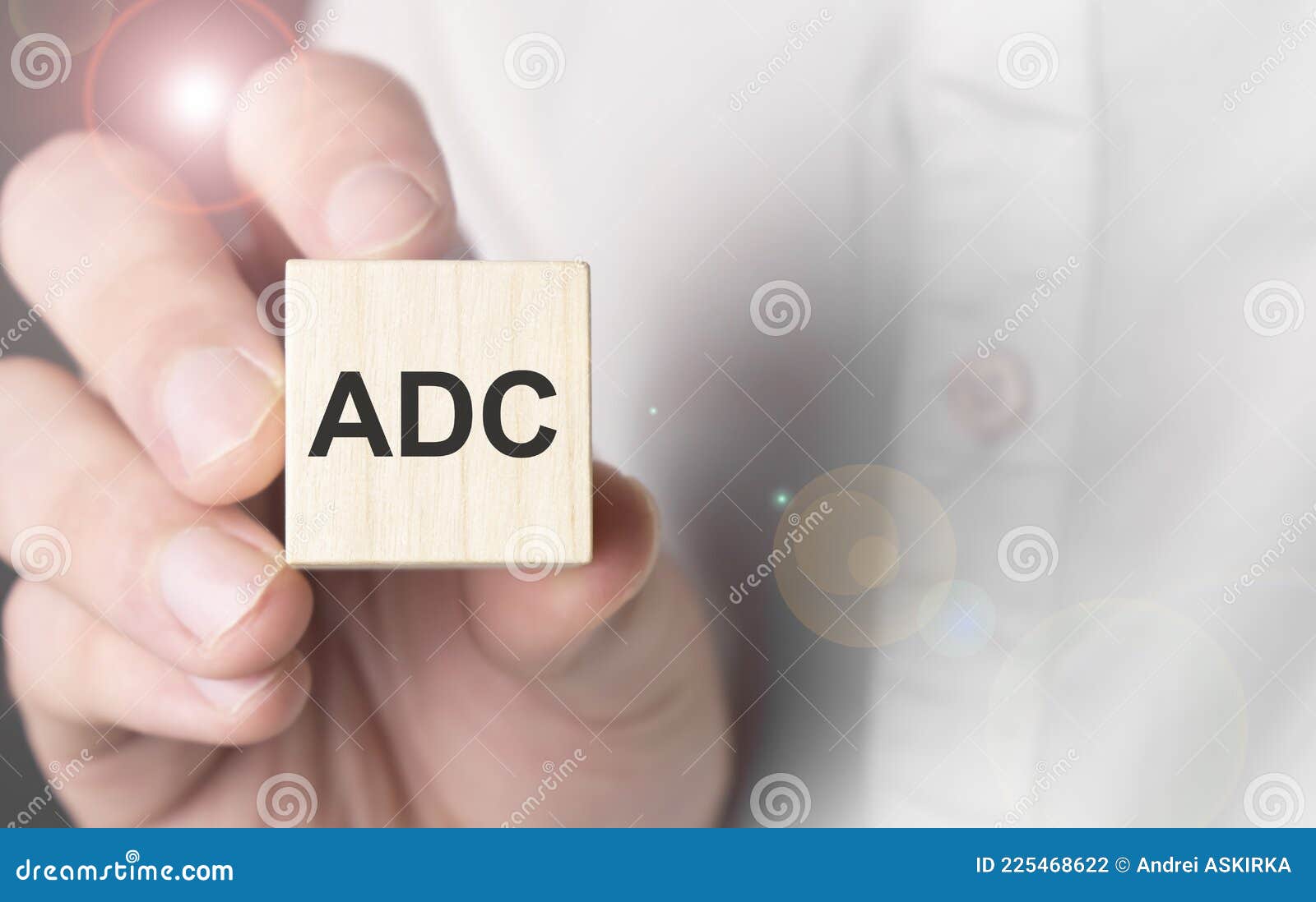 man holding adc word on wooden cube