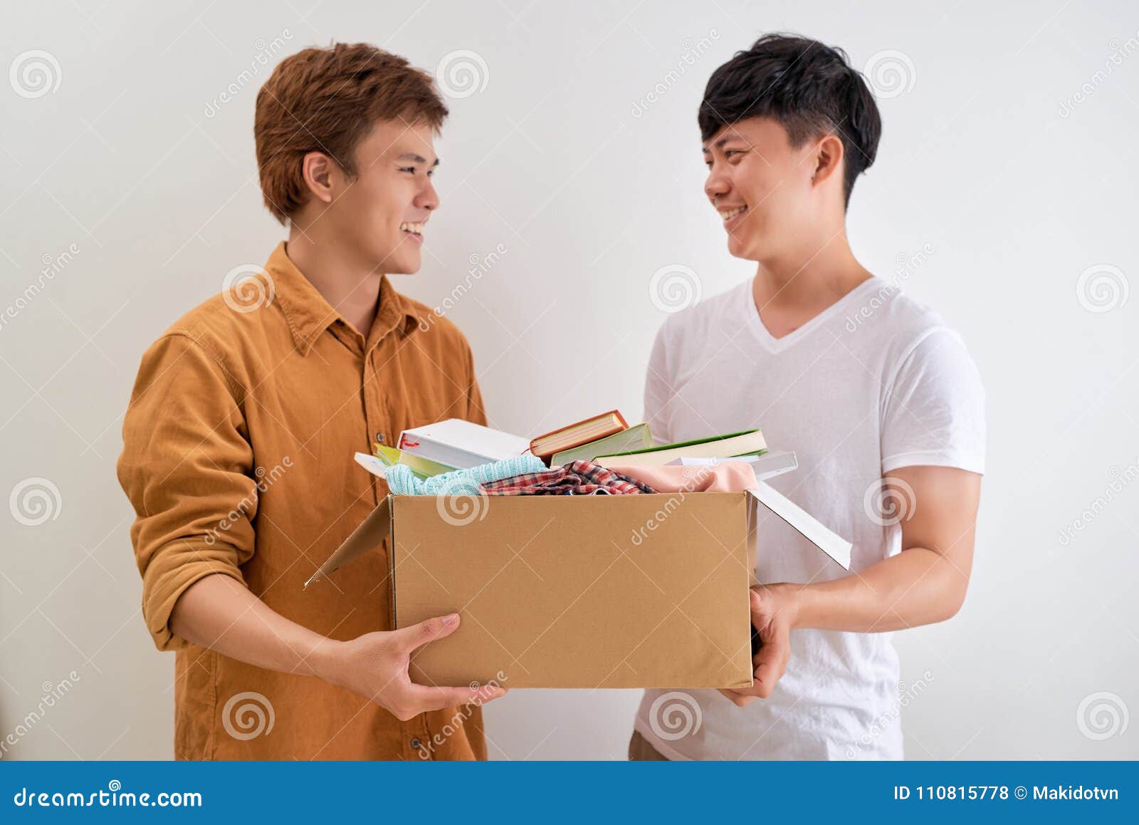 Man Holding a Book and Clothes Donate Box. Donation Concept. Stock