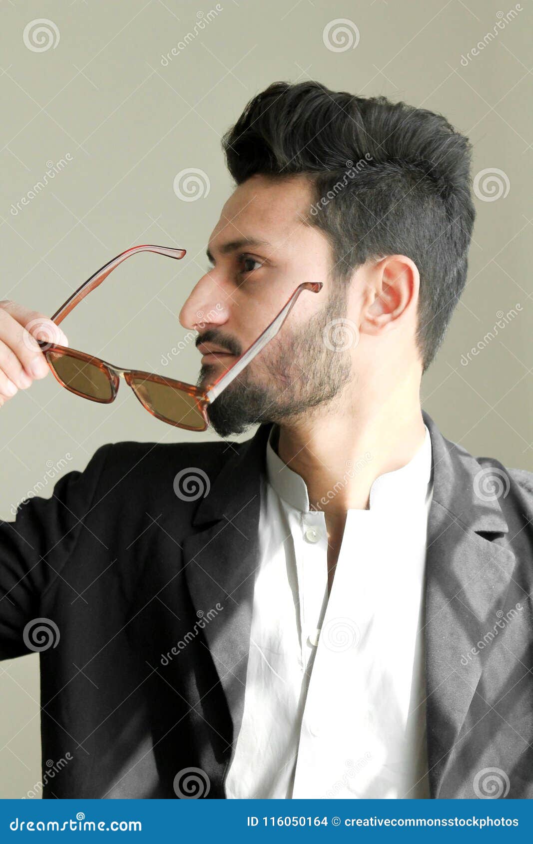 Man Holding Brown Framed Sunglasses With Black Suit Picture. Image