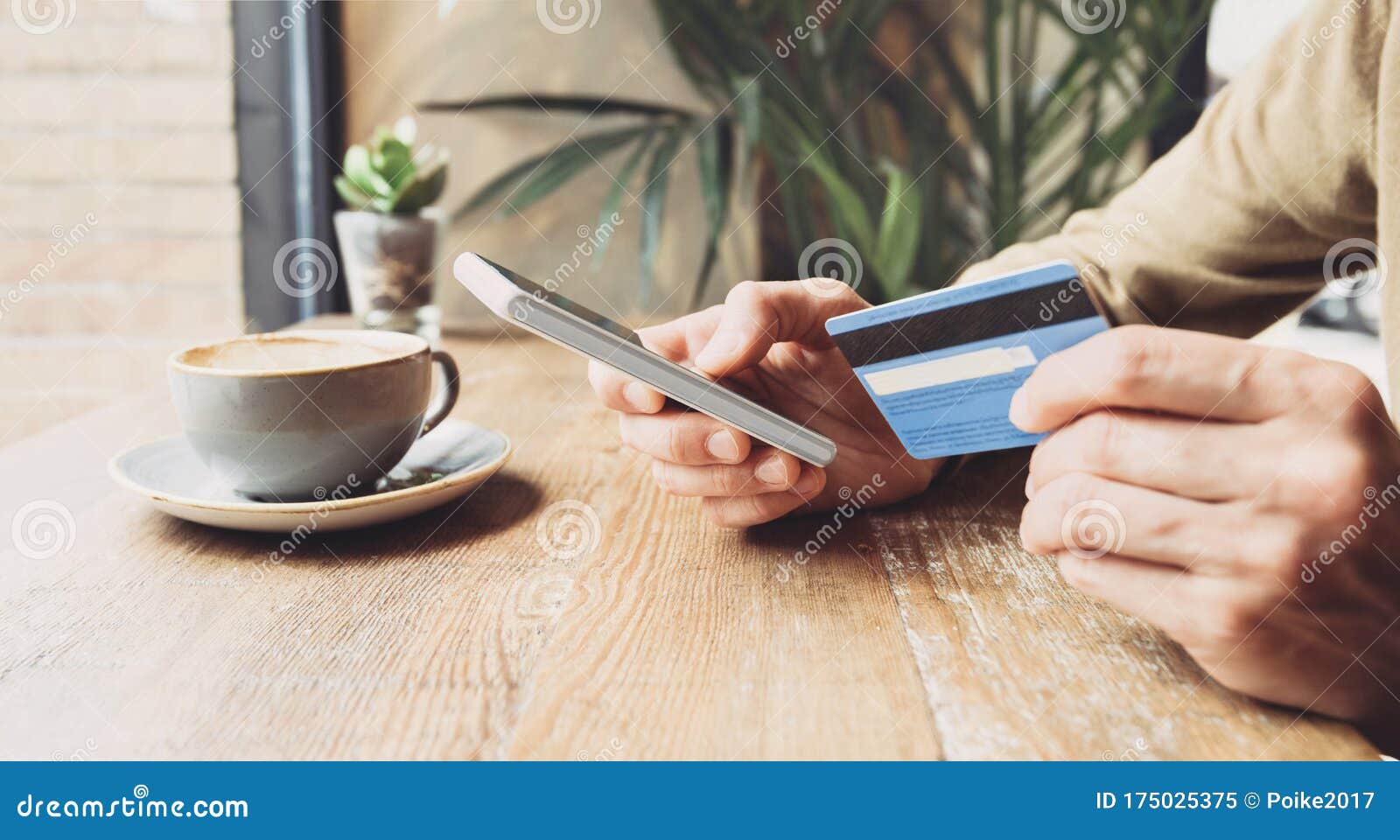 man holding credit card and using smart phone in a cafe, travel, online shopping, ecommerce, internet banking, finance and freelan