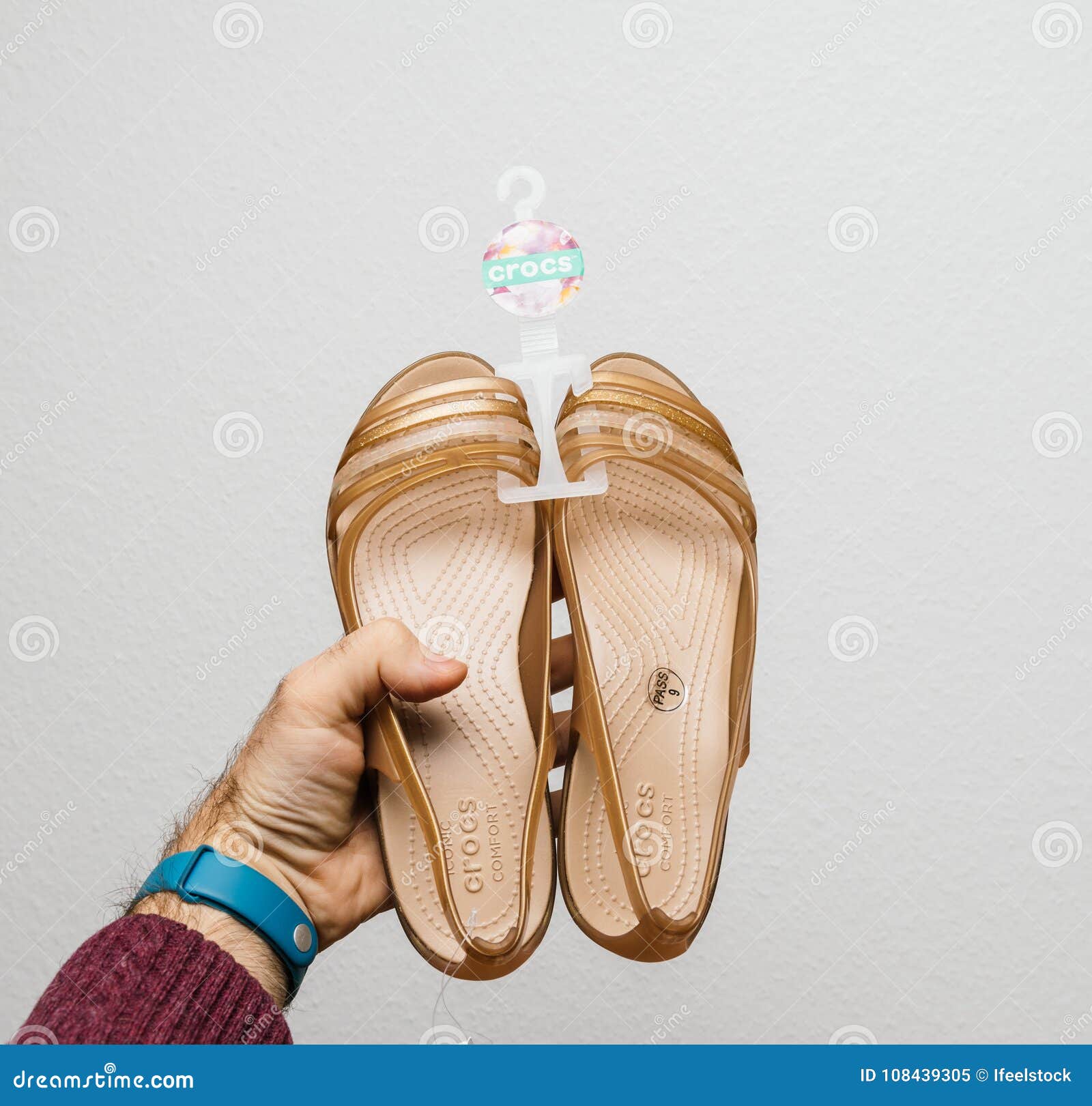 Man Holding Crocs Female Shoes