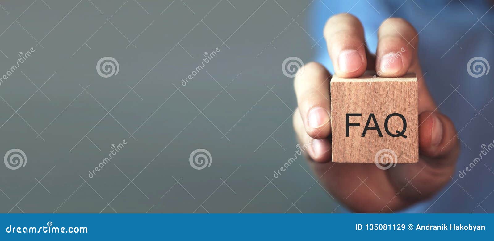 man holding faq message on wooden cube. frequently asked questions