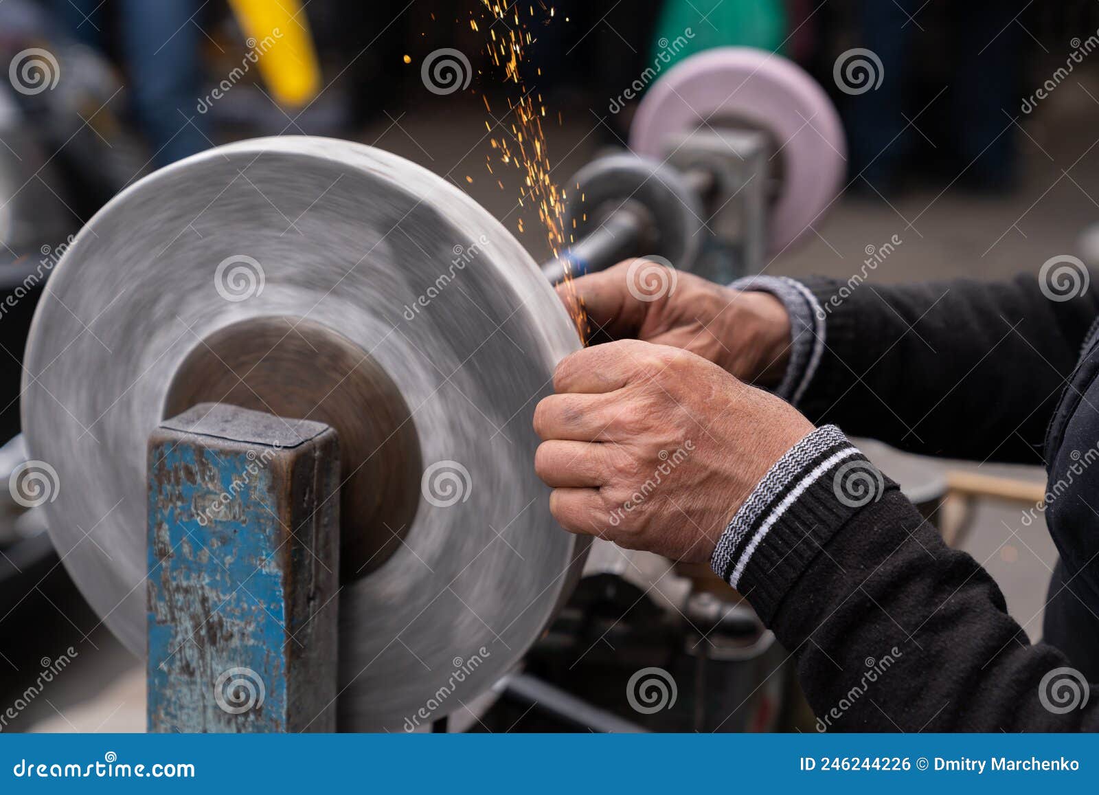Master Sharpens Ax on Electric Sharpener with Bright Sparks and Holds