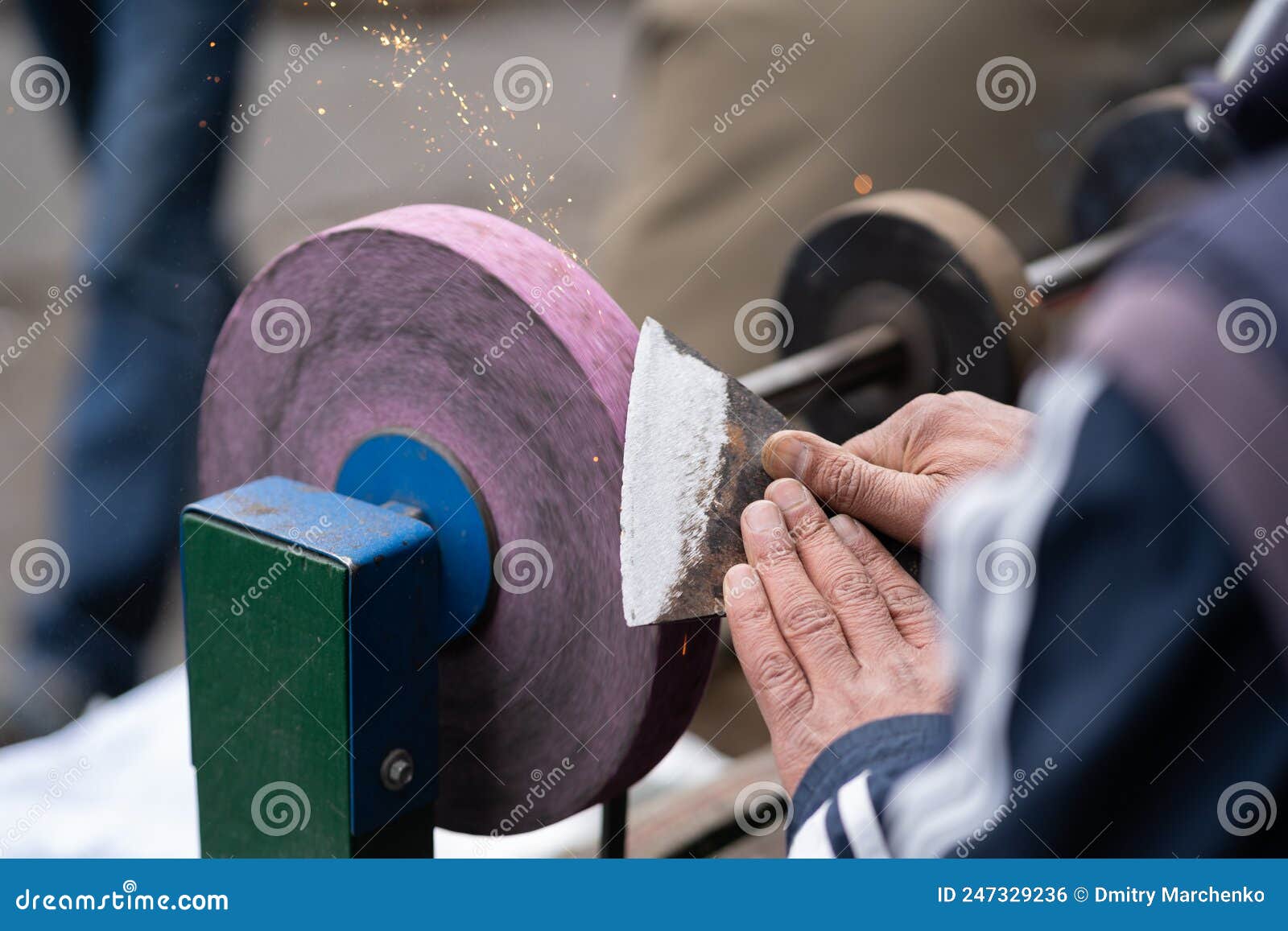 Master Sharpens Ax on Electric Sharpener with Bright Sparks and Holds