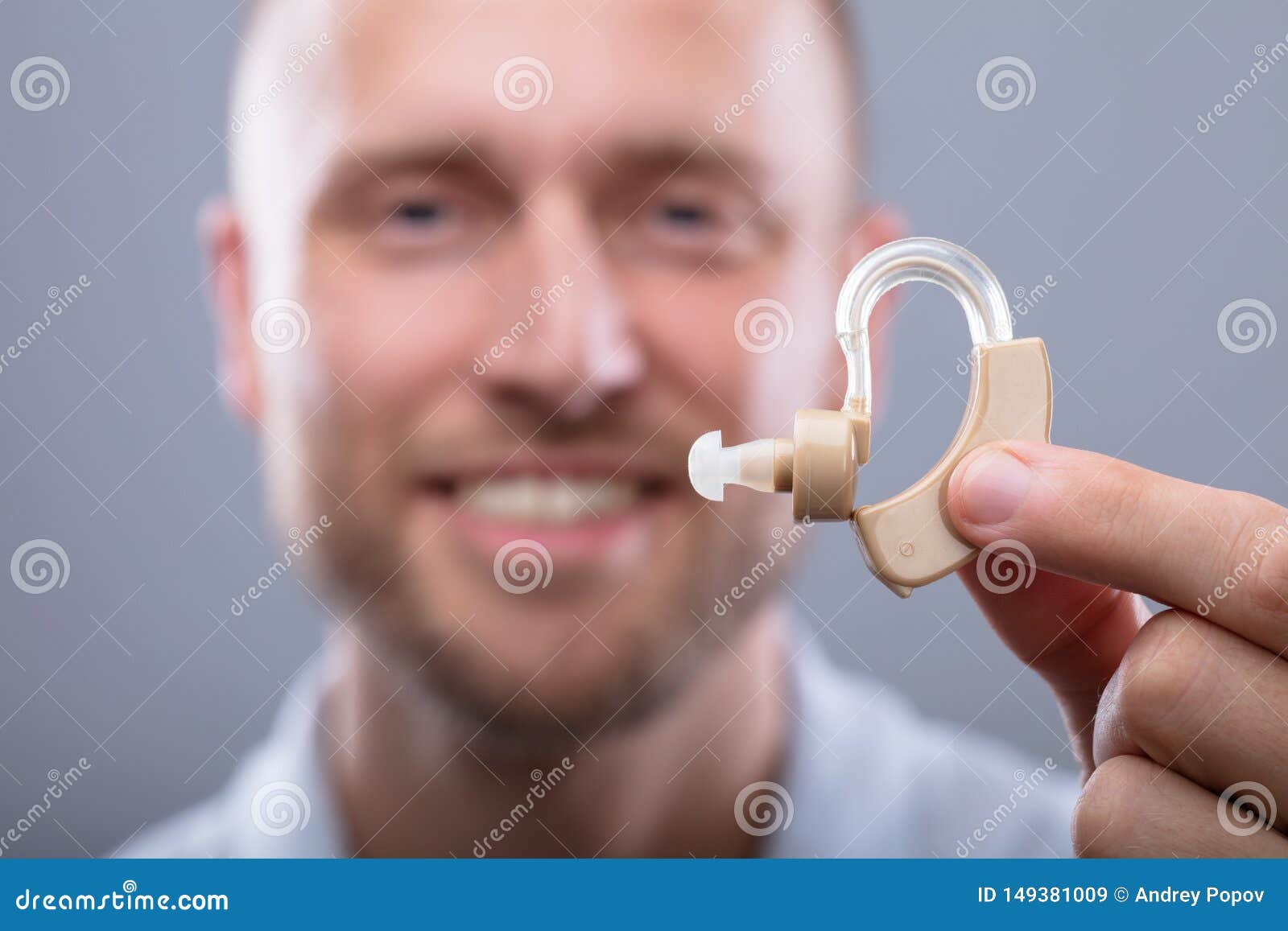Man Holding Hearing Aid stock image. Image of finger 149381009