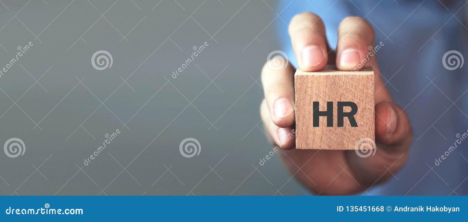 man holding hr word on wooden cube