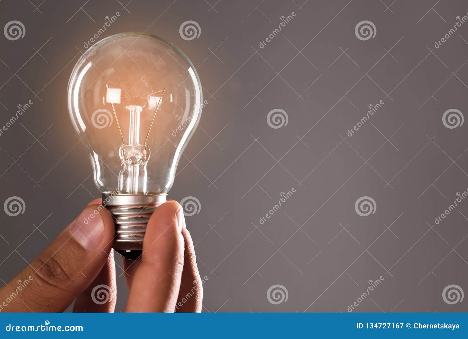 Man Holding Lamp Bulb Against Gray Background Stock Image Image of