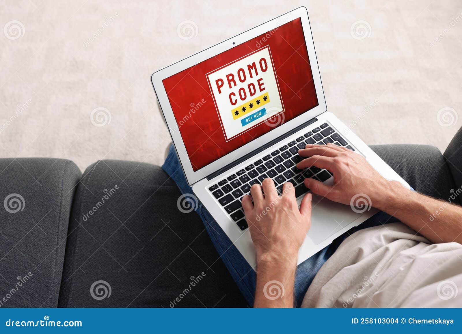 Man Holding Laptop with Activated Promo Code on Sofa, Above View Stock