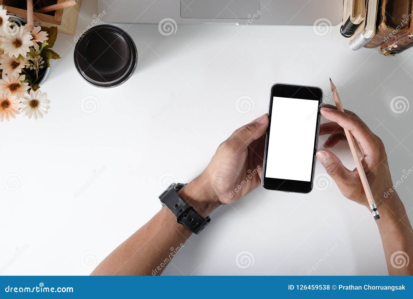 Man Holding Mockup Smartphone On Office Desk. Stock Photo