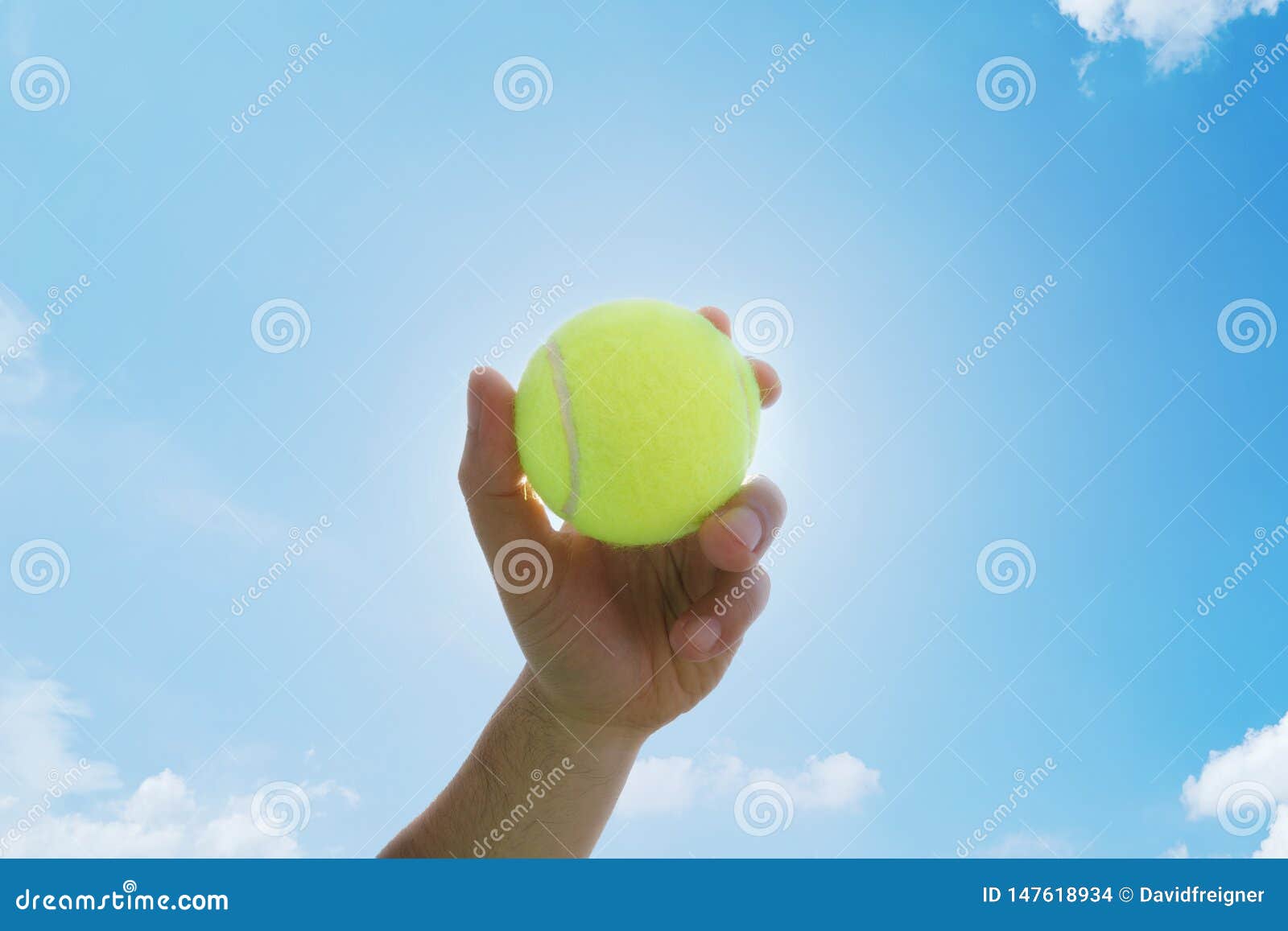 man holding and serving a yellow tennisball against blue sky. sports, competition and fitness concept