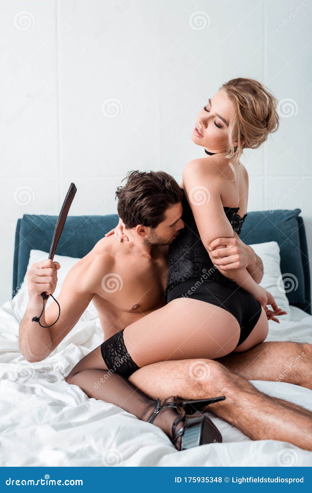 Man Holding Spanking Paddle Near Submissive Stock Photo