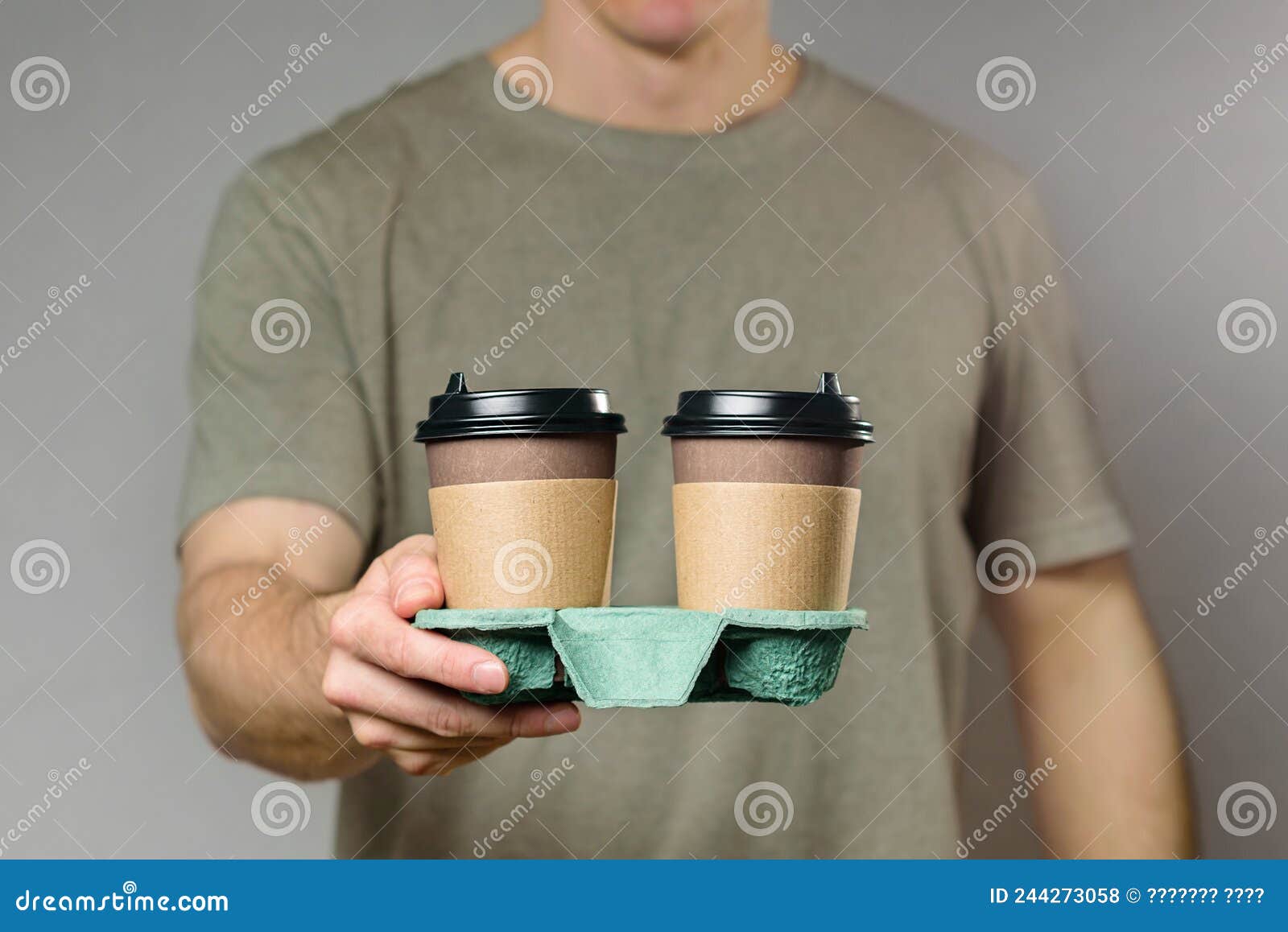 A Man Holds a Cardboard Cup Holder with Two Disposable Coffee Cups