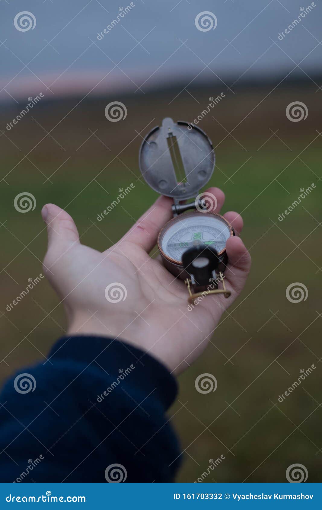 man holds a compass in his hand. man wathing compass holding in his hands