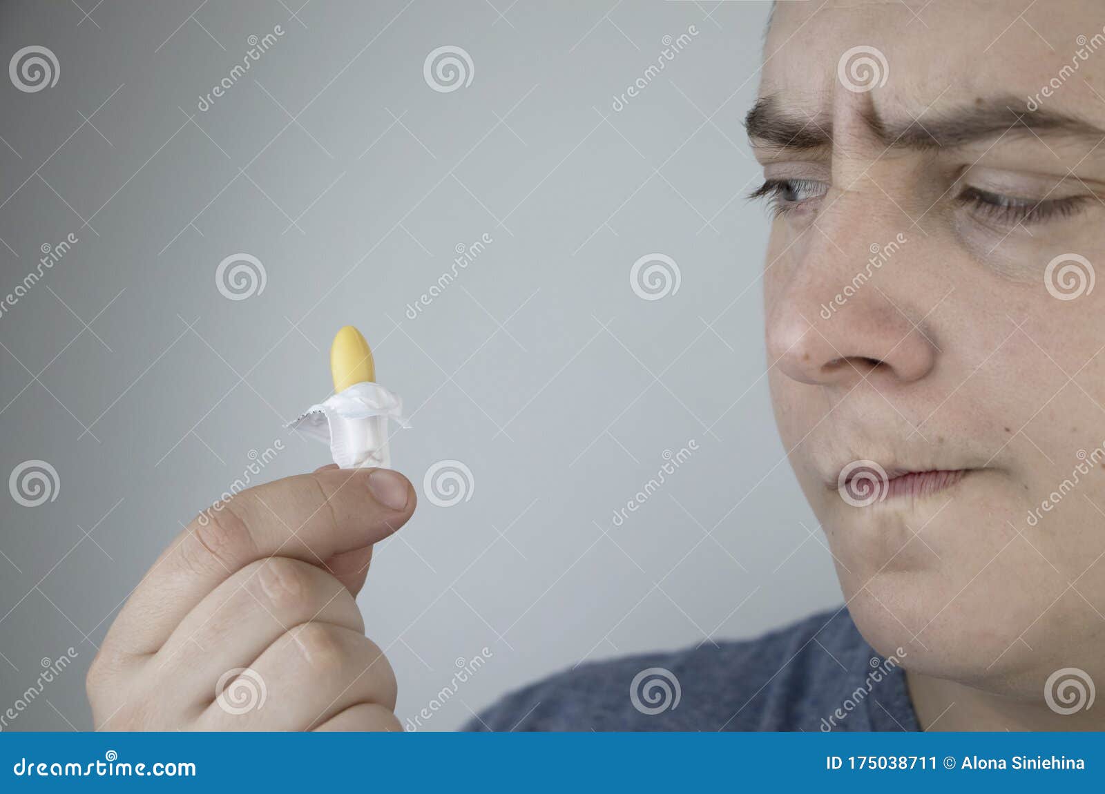 a man holds a rectal candle in his hand. a drug that is inserted into the rectum. rectal suppository for hemorrhoids, constipation