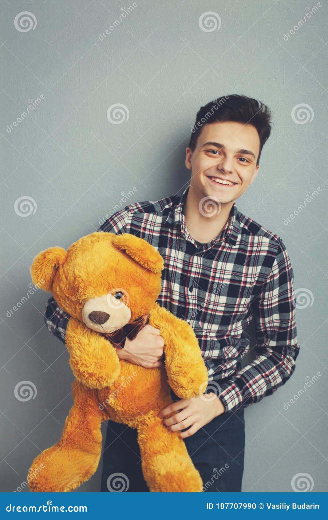 Man Holds Teddy Bear On A Light Blue Background, Copy Space ...