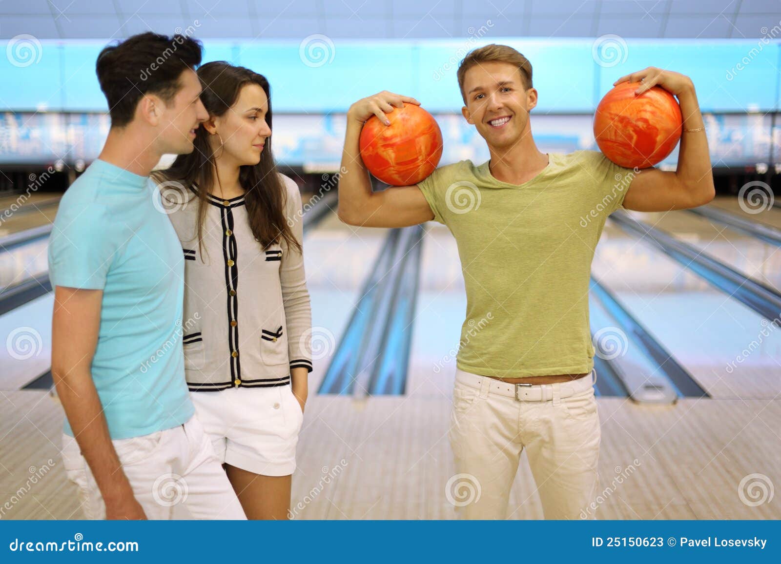 Man Holds Two Balls; Pair Look at Him Stock Image Image of girl
