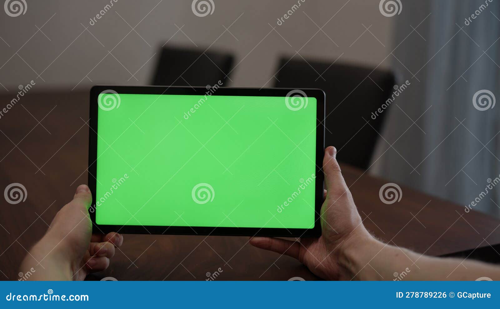 Man at Home Using Tablet Pc with Green Screen while Sitting at the