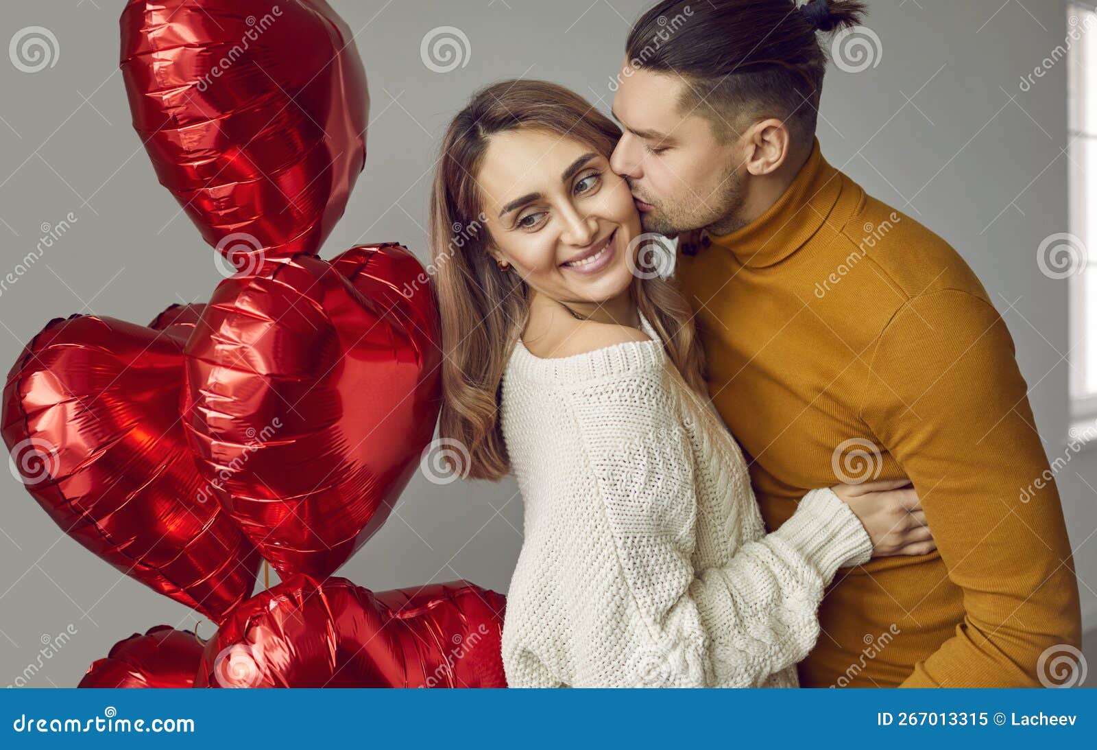 Man Hugs His Woman Kisses Her On The Cheek And Gives Her Red Heart