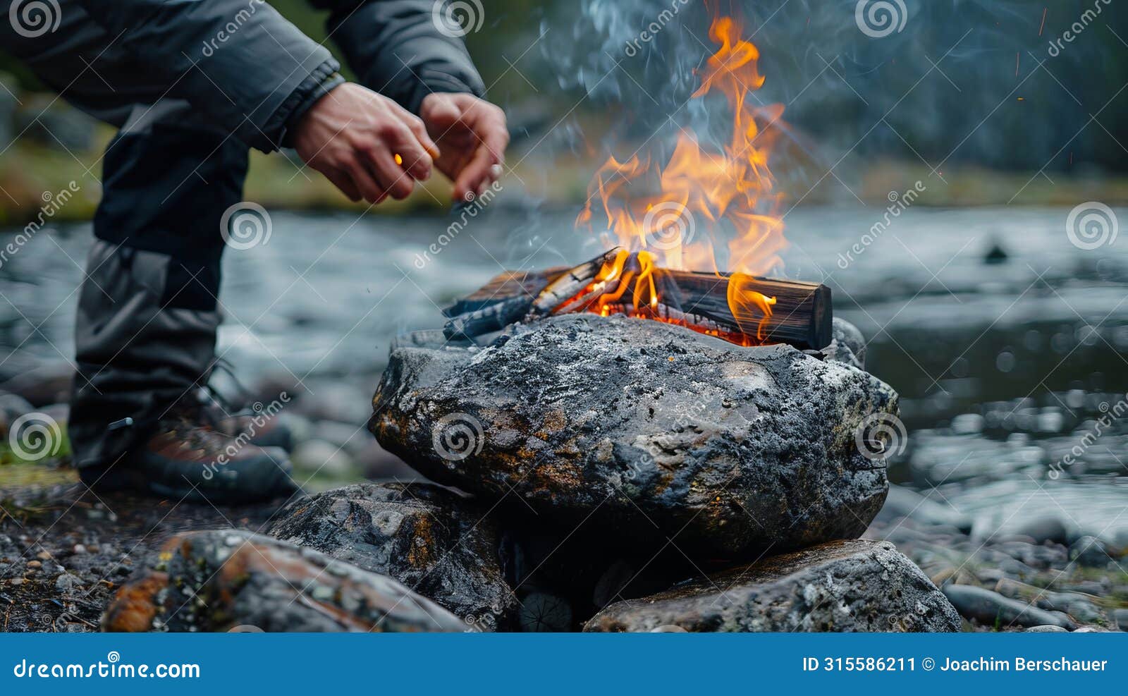 man igniting fire on his meticulously crafted stone grill by the serene riverbank