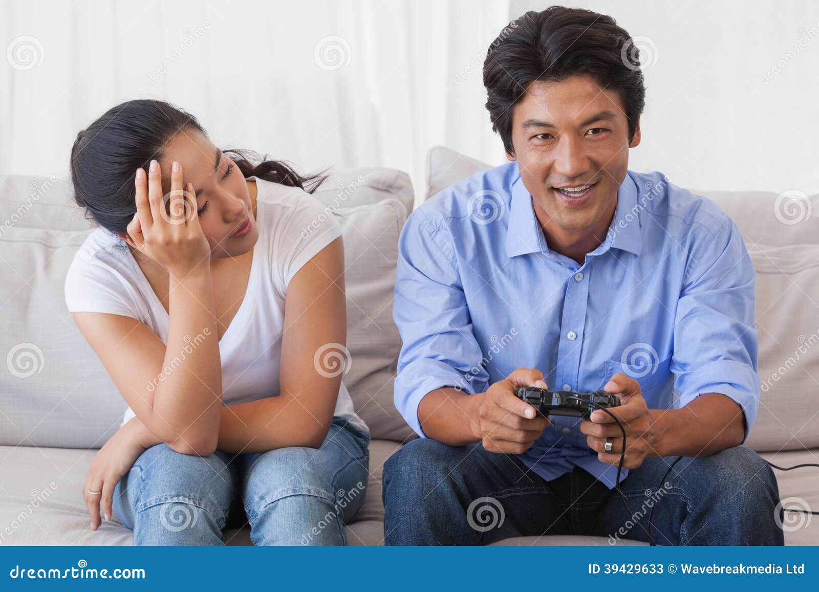 Man disappointed while playing video game with girlfriend at home stock  photo